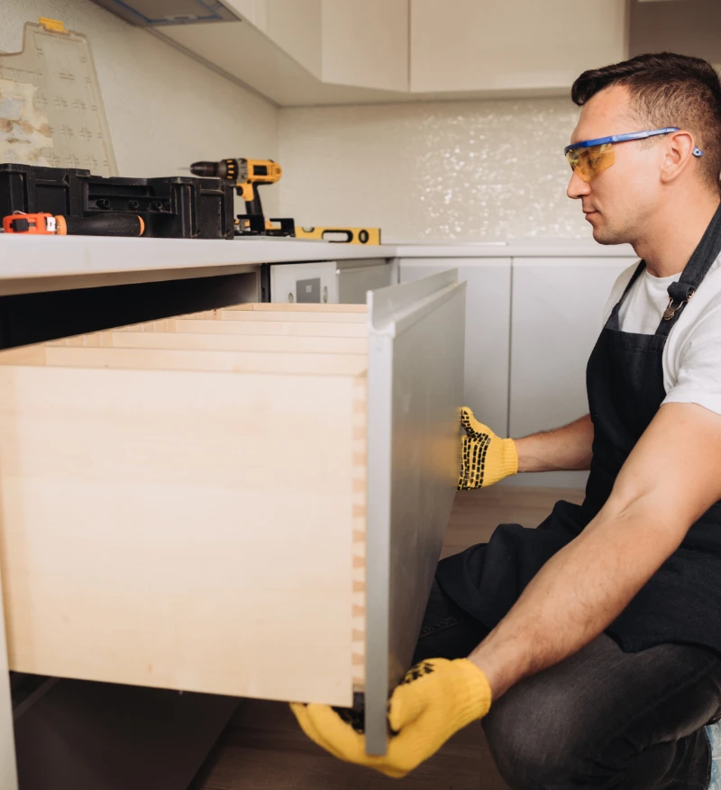 logistics professional wearing yellow gloves installing a large drawer